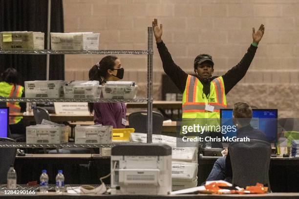 An election worker talks with a colleague during ballot counting at the Philadelphia Convention Center on November 06, 2020 in Philadelphia,...