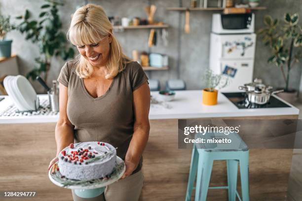 donna che tiene la torta fatta in casa con frutta a bacca - cheesecake foto e immagini stock