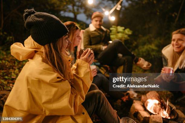 friends drinking mulled wine by the campfire - campfire stock pictures, royalty-free photos & images