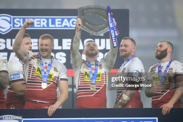 Jackson Hastings of Wigan Warriors lifts the League Leaders' Shield in celebration with his teammates after the Betfred Super League match between...