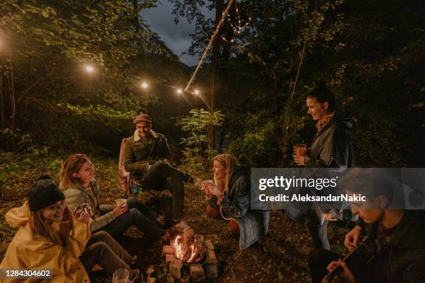 friends camping by the river - warming up stock pictures, royalty-free photos & images