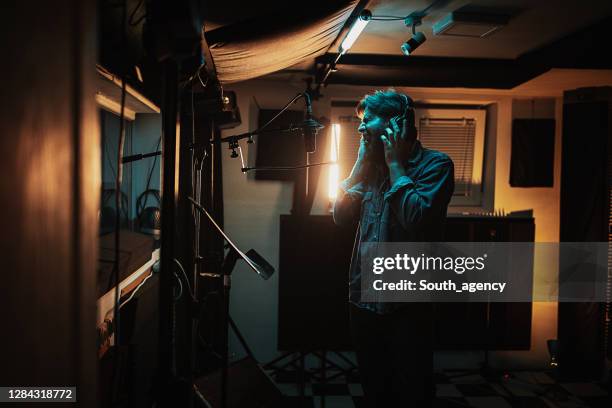 cantante masculino cantando en el micrófono en el estudio de grabación - micrófono de condensador fotografías e imágenes de stock