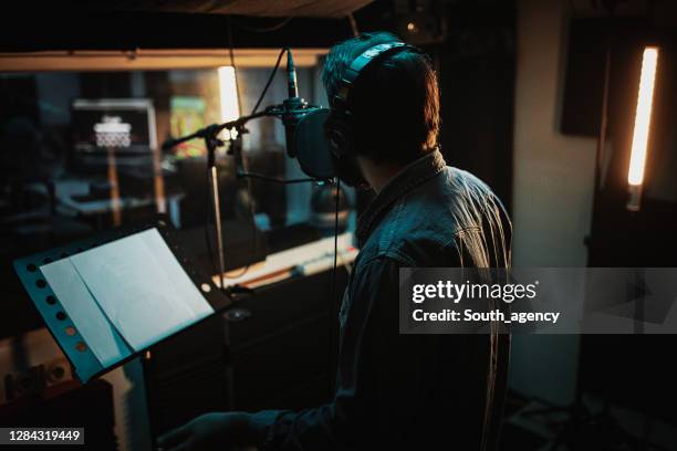 male singer singing into microphone in recording studio - lyric stock pictures, royalty-free photos & images