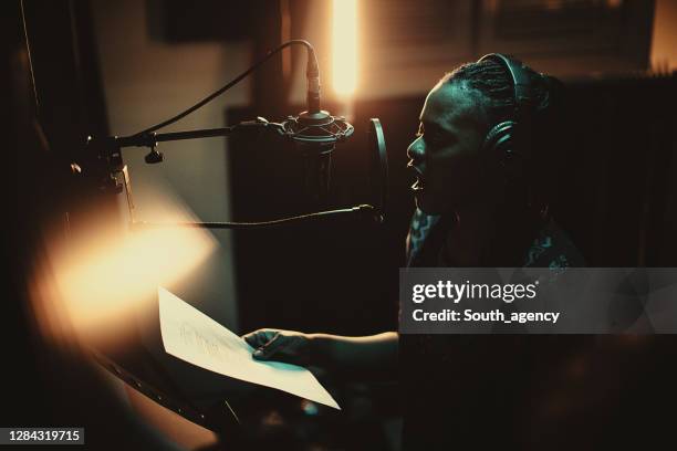 black female singer singing into microphone in recording studio - lyric stock pictures, royalty-free photos & images