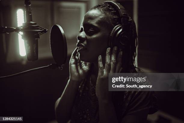 hermosa joven afroamericana cantante cantante grabación canción en el estudio - música soul fotografías e imágenes de stock