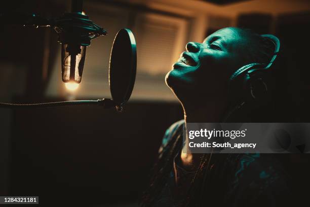 junge afroamerikanische sängerin nimmt song im musikstudio auf - soul music stock-fotos und bilder