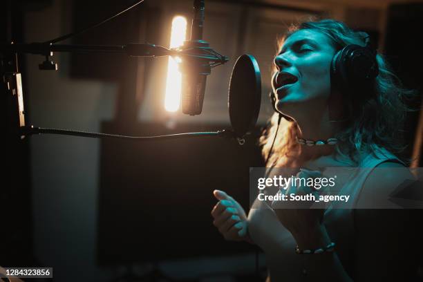 jeune belle chanson d’enregistrement de chanteur féminin dans le studio de musique - musique soul photos et images de collection