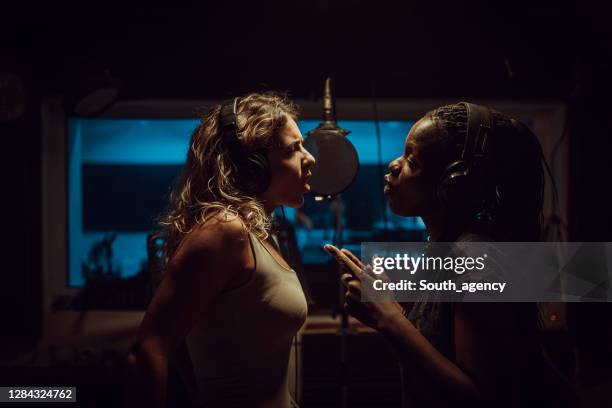 female duet recording song in music studio - duet stock pictures, royalty-free photos & images