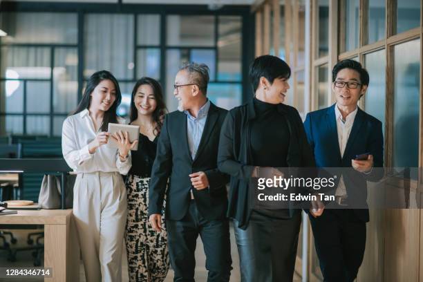 group of asian chinese successful office management team having discussion while walking toward camera - asia stock pictures, royalty-free photos & images