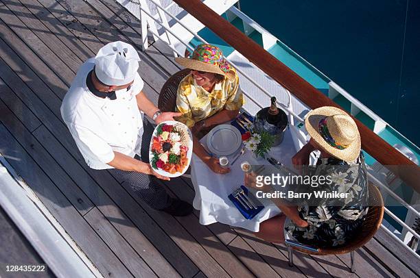 couple receiving meal on deck of passenger liner - couple on cruise ship stock pictures, royalty-free photos & images