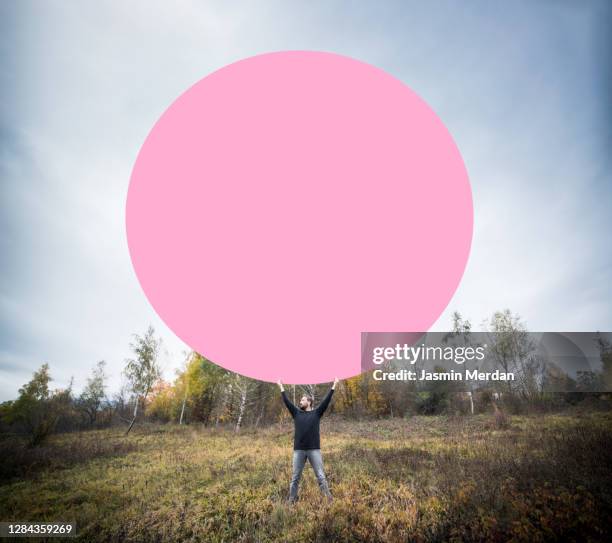 man on landscape holding fantasy pink circle - concepts and ideas - burgundy stock pictures, royalty-free photos & images