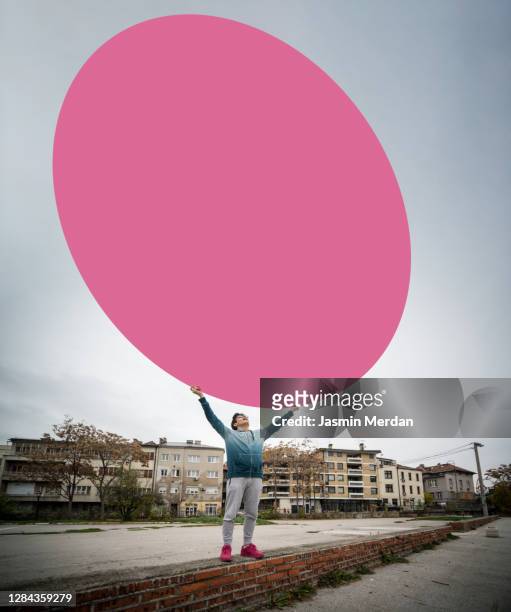 boy holding big circle on city street - anti aircraft stock-fotos und bilder