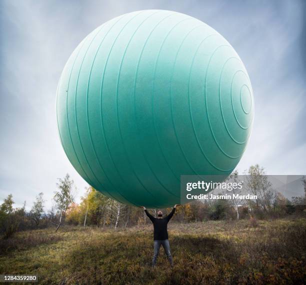 man with giant ball in nature - 特大 個照片及圖片檔