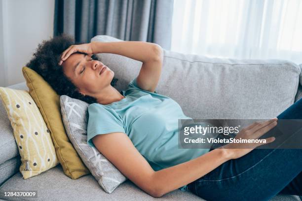 woman with high fever at home. - women lying imagens e fotografias de stock
