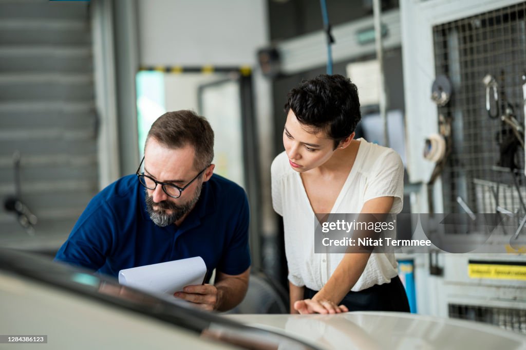 Car Insurance Claims. Insurance adjuster explaining damage of car exterior to customer at Auto Repair Center. Business hour 24/7 service coverage. Customer Service, Quality of Service.