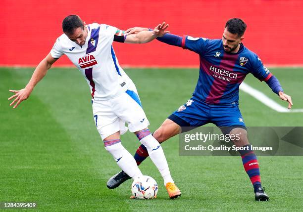 Pablo Insua of SD Huesca competes for the ball with Kike Garcia of SD Eibar during the La Liga Santander match between SD Huesca and SD Eibar at...