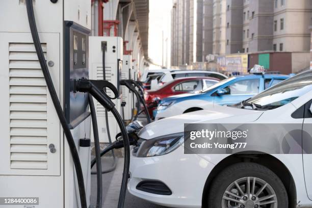 electric vehicles are charging at the urban public charging station - tesla truck stock pictures, royalty-free photos & images