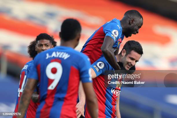 Scott Dann of Crystal Palace celebrates with teammates after scoring his team's first goal during the Premier League match between Crystal Palace and...