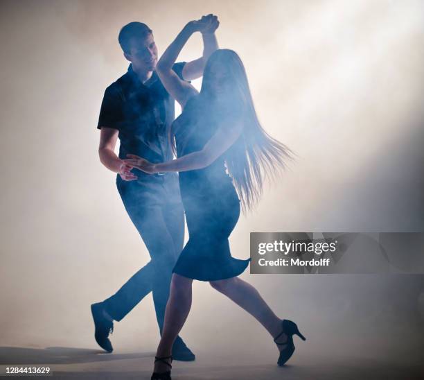 attractive couple of young dancers are performing latin-american dance - salsa imagens e fotografias de stock