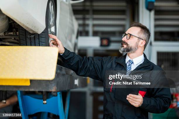 vehicle claims history report. car insurance agent analyzing damage assessment of car exterior and record in mobile application at auto repair center. business hour 24/7 service coverage. customer satisfaction and quality of service. - car insurance agent stock pictures, royalty-free photos & images