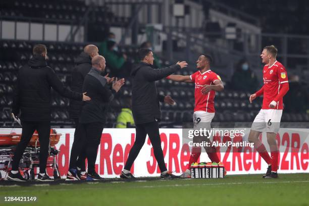 Victor Adeboyejo of Barnsley celebrates with the Barnsley back room staff after scoring his team's second goal during the Sky Bet Championship match...