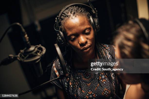 twee vrouwelijke singers die een duet in opnamestudio samen zingen - duet stockfoto's en -beelden