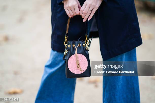 Sara Carnicella wears a black and pink leather Fendi bag, flared jeans, on November 06, 2020 in Paris, France.