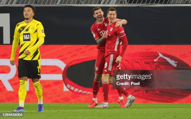 Robert Lewandowski of Muenchen celebrates his team's second goal with teammate Lucas Hernandez as Jadon Sancho of Dortmund reacts during the...