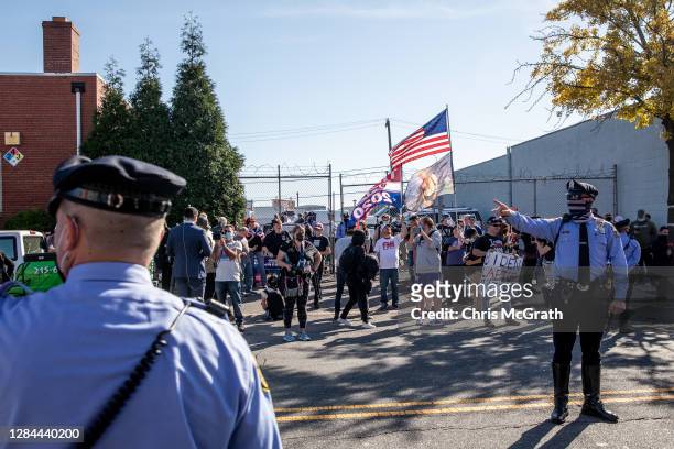 Police officers direct traffic as supporters of President Donald Trump gather outside a press conference where attorney for the President, Rudy...