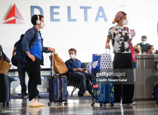 Air travelers stand by a boarding gate in John F. Kennedy International Airport on November 07, 2020 in New York City. The global pandemic has had a...