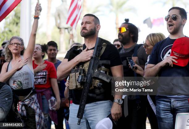 Supporters of President Donald Trump listen to the national anthem at a ‘Stop the Steal’ rally in front of the State Capitol on November 7, 2020 in...