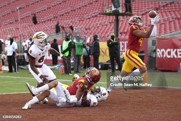 Bru McCoy a deflected pass intended for Amon-Ra St. Brown of the USC Trojans for a touchdown as Timarcus Davis and DeAndre Pierce of the Arizona...