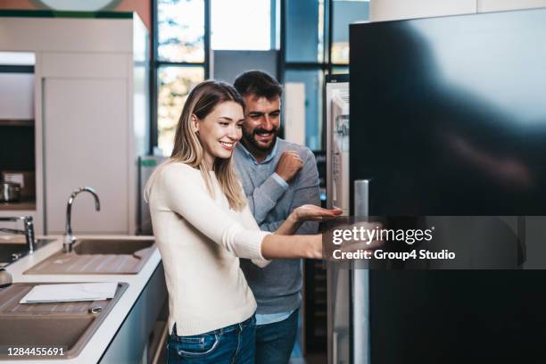 junges paar beim einkaufen - haushaltsmaschine stock-fotos und bilder