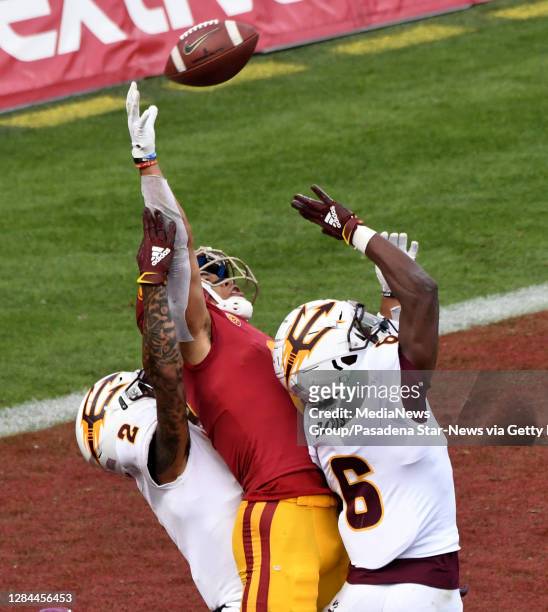 Wide receiver Amon-Ra St. Brown of the USC Trojans can"u2019t reach a pass in the end zone between defensive back DeAndre Pierce and defensive back...