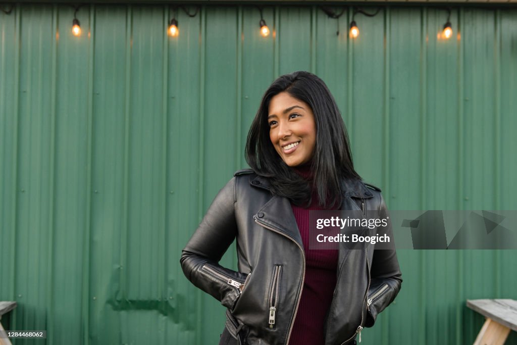 Portret van Aziatische Amerikaanse Vrouw in LeerJasje Buiten Groene Muur in Upstate New York