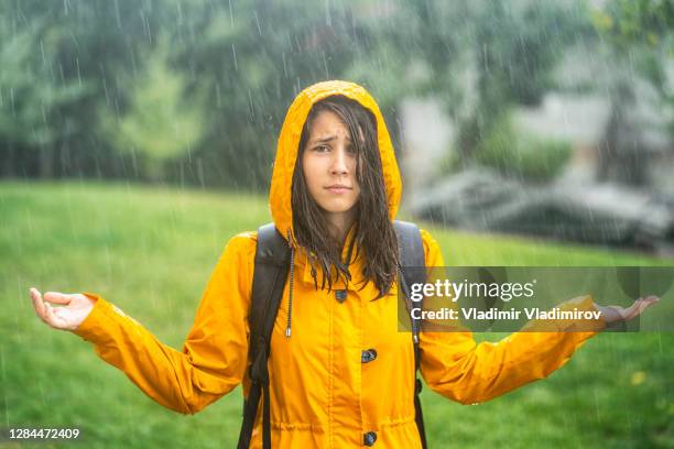 chica de pie mojada bajo la lluvia - anegada fotografías e imágenes de stock