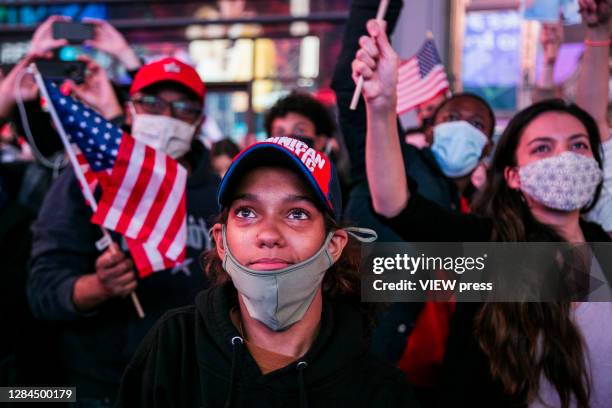 Girl looks at screens in Times Square after it was announced that Democratic candidate Joe Biden would be the next president of the United States on...