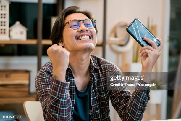 asian man playing video game - mobile game stock pictures, royalty-free photos & images