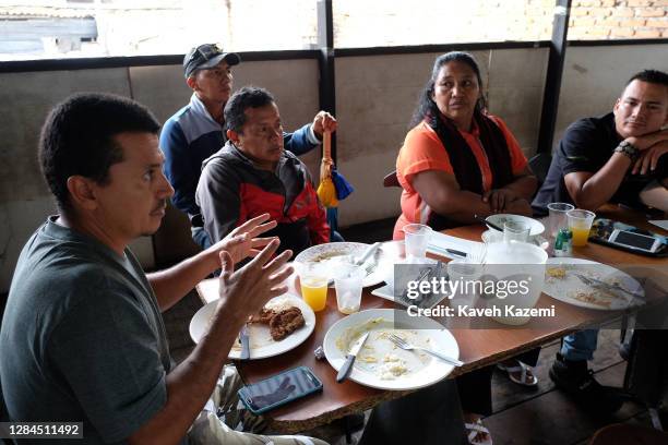 Community leaders of different ethnicities gather to discuss problems prevailing after the peace process over lunch while an indigenous guardsman...