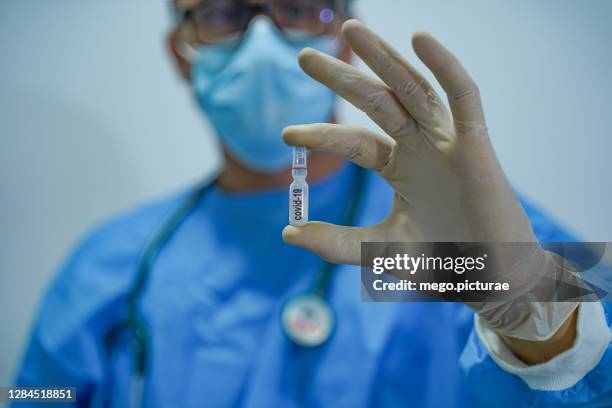 doctor showing capsule with vaccine for covid-19 - hospital orderly stock pictures, royalty-free photos & images