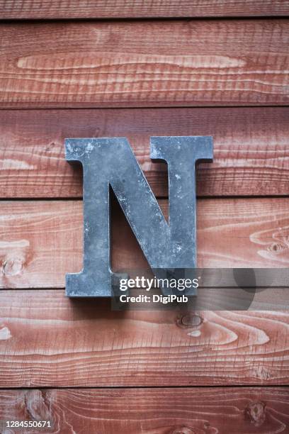 iron sheet 3d capital letter n on plank wall - letter n - fotografias e filmes do acervo