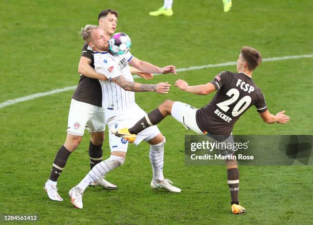 James Lawrence and Finn Ole Becker of St. Pauli challenge Philipp Hofmann of Karlsruhe during the Second Bundesliga match between FC St. Pauli and...