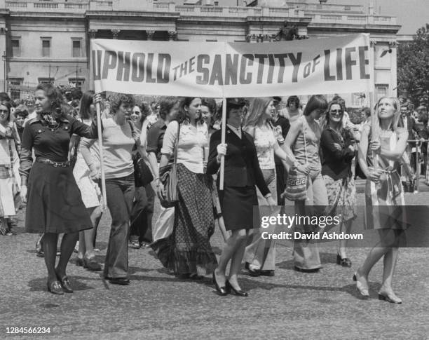 Group of young women carrying a banner reading 'Uphold the Sanctity of Life' as they walk from Trafalgar Square to Downing Street to deliver a letter...