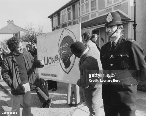 British Labour Party politician Peter Hain speaks with ANC activist Isaiah Stein as they prepare a banner beside a police officer ahead of the rugby...