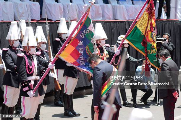 Newly elected President of Bolivia Luis Arce kisses the Whipala flag as Vice President David Choquehuanca kisses the Bolivian flag after the swearing...
