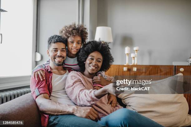 portret van gelukkige afrikaanse amerikaanse familie die tv let - african family watching tv stockfoto's en -beelden