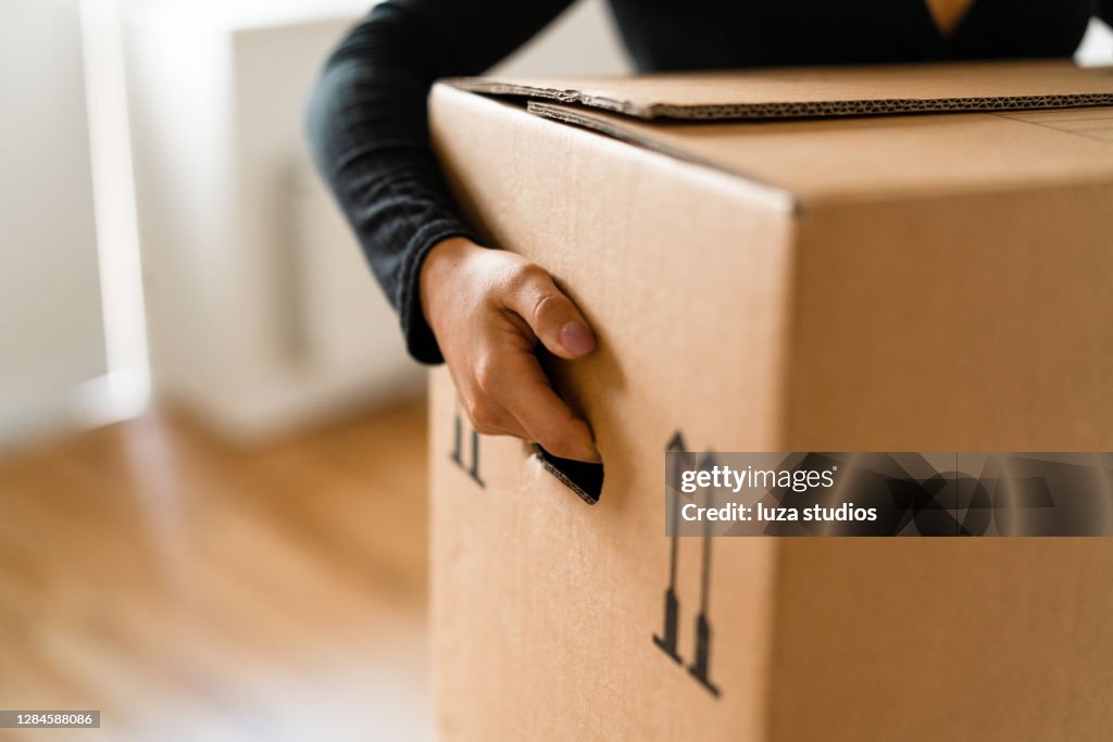 Mujer llevando cajas a su nuevo hogar
