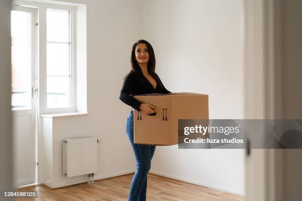 woman carrying boxes into her new home - looking around stock pictures, royalty-free photos & images