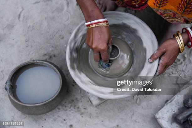 woman potter makes earthen lamps ahead of diwali - an artist makes earthen lamps for diwali festival stock pictures, royalty-free photos & images