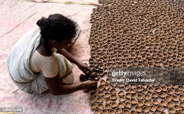 woman potter makes earthen lamps ahead of diwali - an artist makes earthen lamps for diwali festival stock pictures, royalty-free photos & images